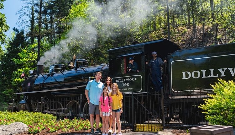 Family posing in front of Dollywood Express