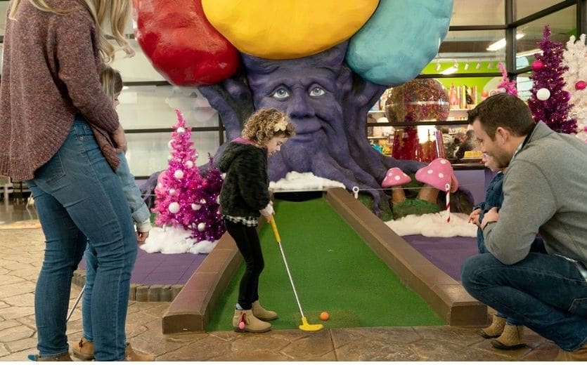 Family playing mini-golf at Christmas at Crave Golf