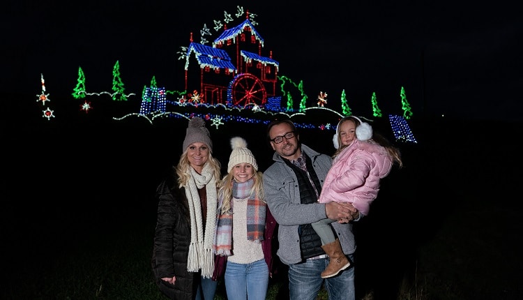 Family in front of Winterfest Old Mill Scene