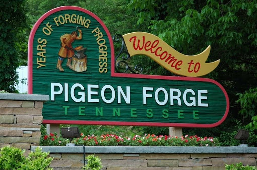 Welcome to Pigeon Forge Tennessee entrance green sign in the woods.