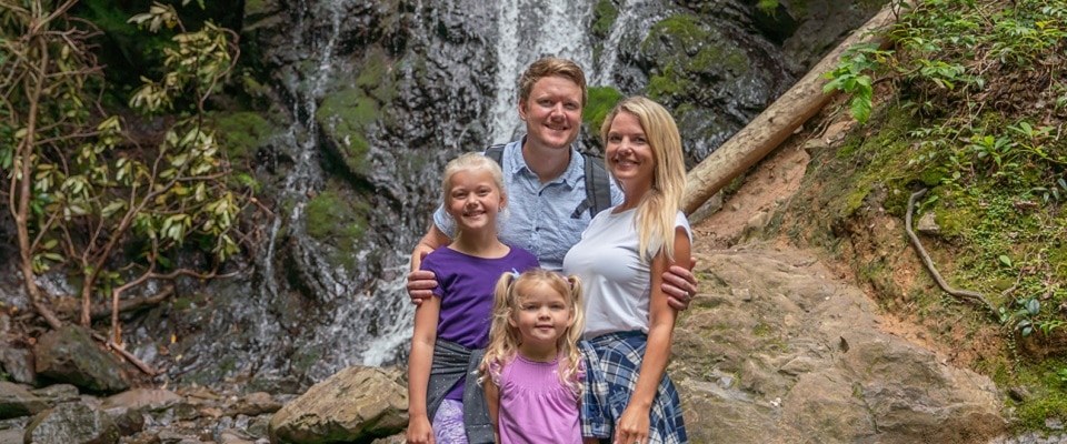 Family posing in front of waterfall in Great Smoky Mountains