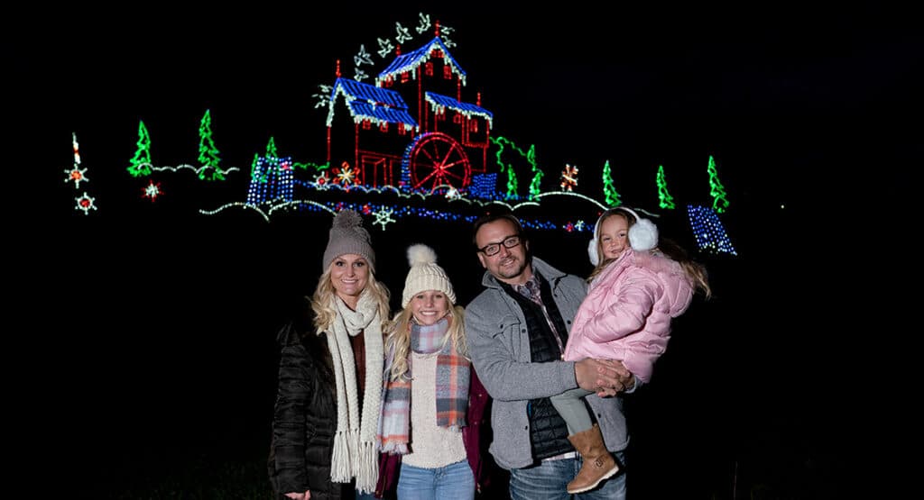 Family in front of Winterfest Old Mill Scene