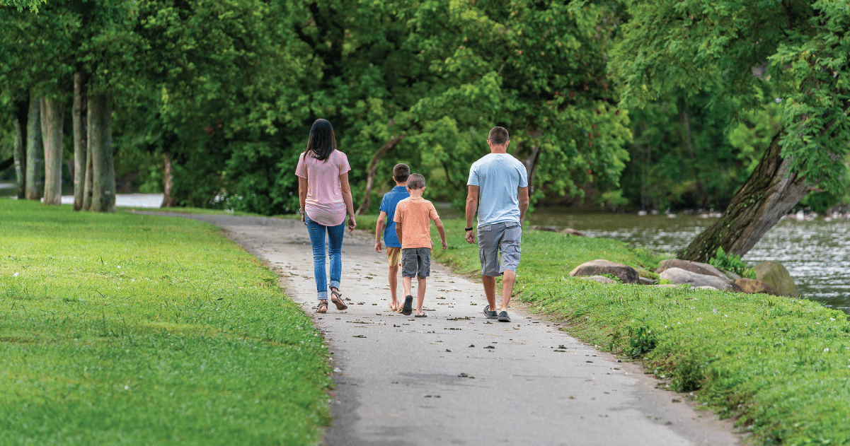 image of family taking a walk at riverwalk trail in peigon forge 